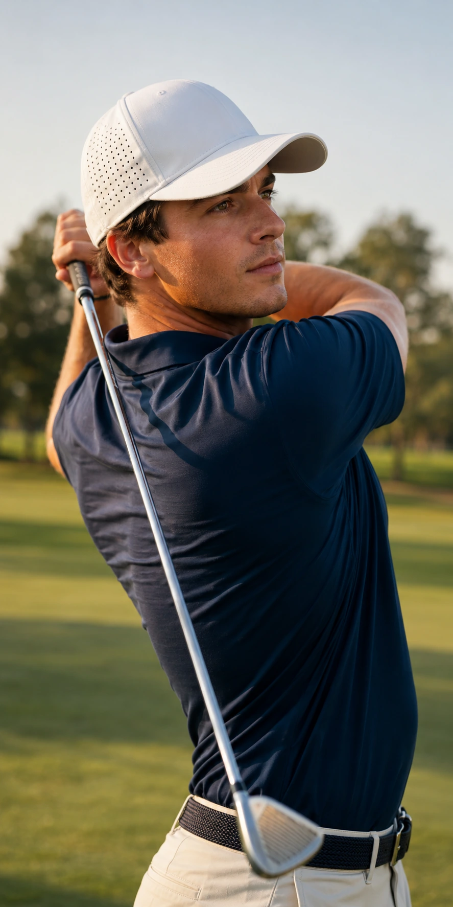 Golfer wearing a white laser-perforated performance cap